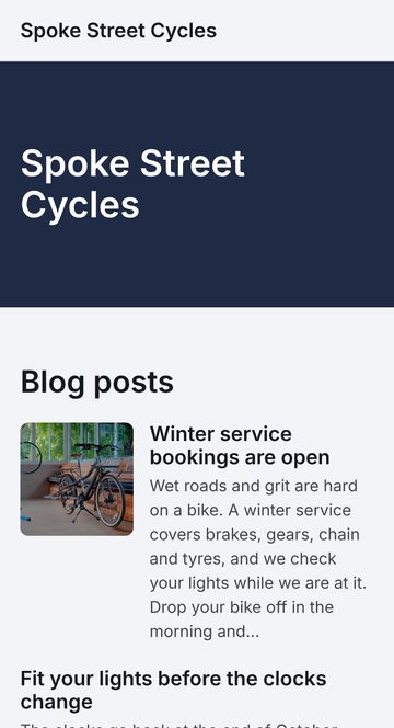 Home page of Spoke Street Cycles’ example Stratafold-hosted website at phone width: a navy band with plain lettering, then its blog posts